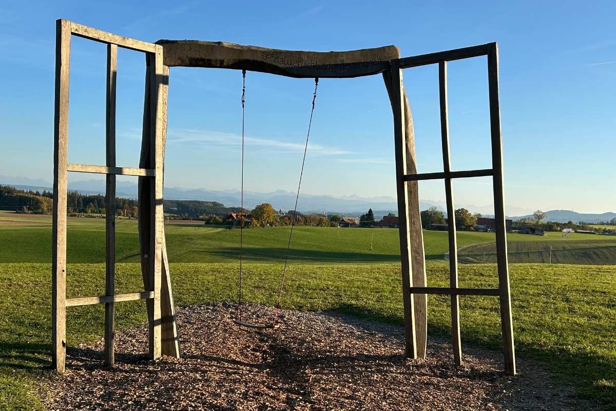 Holzrahmen mit Schaukel als Symbol für Abschied und Übergang in einen neuen Lebensabschnitt