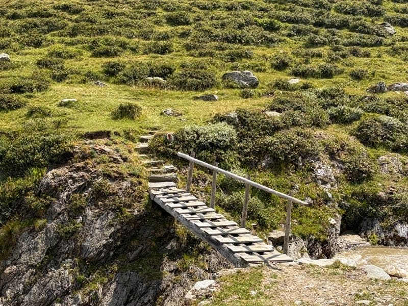 Kleine Holzbrücke auf einem Weg in den Bergen